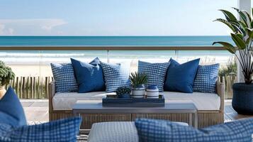 As you step out onto the balcony you are greeted with stunning views of the beach and ocean. The outdoor seating area is adorned with plush blue and white cushions creating the perfect photo