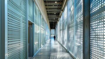 Walking through a narrow corridor visitors are surrounded by high walls adorned with large panels of textured metal grating. The panels create a sense of depth and movement as light photo