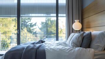 A bedroom with smart glass windows adjusted to a dark tint providing privacy and keeping out harsh sunlight during daytime hours. This helps maintain a consistent temperature in the photo