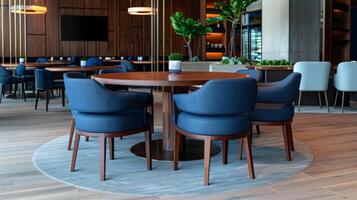 el mesa es rodeado por cómodo sillas tapizado en un suave Armada azul tela. cada asiento es equipado con un pequeño tableta ese permite usted a personalizar tu comida experiencia foto