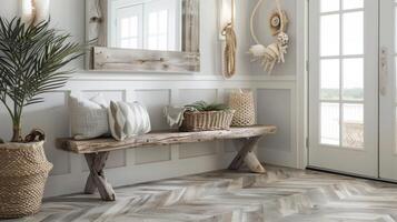 Finally the entryway of the beach house showcases a stunning LVT flooring in a herringbone pattern. The walls are painted in a soft light gray and a large mirror framed in driftwood photo