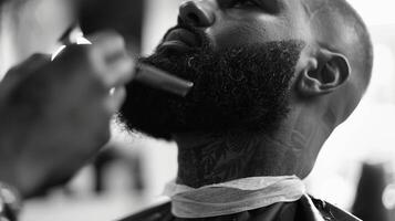 Amidst the aromatic scents of hair products and the gentle hum of clippers a multicultural barber carefully trims a customers beard. He takes great pride in not only perfecting the photo