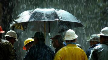 Under a large umbrella a group of roofers gather together strategizing and planning their next move in the midst of a heavy rainstorm. photo