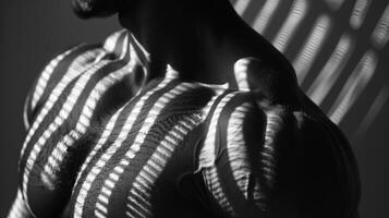 The intricate interplay of light and shadow on the flexed abs highlights the dedication and strength of the athlete. photo