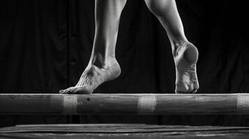 The smooth defined muscles of a gymnasts arms and legs move with precision and control on the balance beam. photo