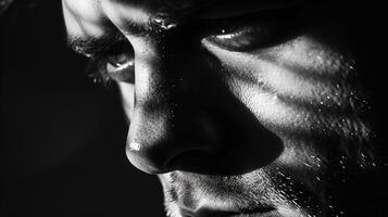 In the hollows of his the shadows accentuate the sharp lines and contours of his facial muscles. photo