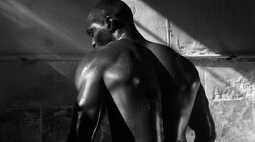 As he leans forward the interplay of shadows and muscles creates a rippling effect across his back. photo