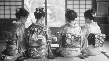 Four women in elegant kimonos gather around a low table backs turned away as they participate in a mindful tea ceremony. The . photo