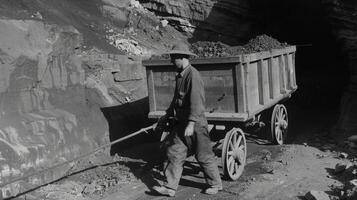 A miner using a trolley to transport coal to the mouth of the mine photo