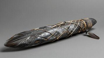 un hermosamente tallado obsidiana espada envuelto en cuero y adornado con plumas usado para ceremonial tintineo y dejando foto