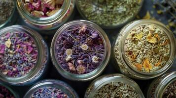 An array of dried herbs and flowers such as chamomile rose and lavender are carefully p in jars for use in creating custom aromatherapy blends photo