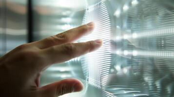 A macro shot of a finger pressing down on the activation button of a smart glass control panel. The electrical signals generated by this action will cause the glass to chang photo