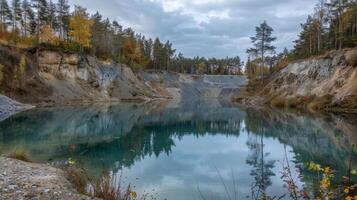 The nowstill water of a deserted mine pit once filled with the sounds of blasting and heavy machinery photo