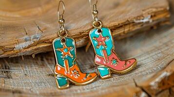 A playful pair of dangle earrings featuring a whimsical combination of cowboy boots pistols and sheriff badges in brightly colored enamel photo