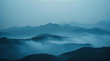 The mountains appearing faded and distant obscured by the thick fog photo