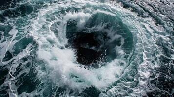 The fierce motion of the whirlpool causes the surrounding waves to crash and collide creating a chaotic scene photo