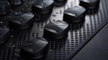 An angled closeup of a matte black control panel showcasing a series of embossed buttons with a geometric pattern etched into each one photo