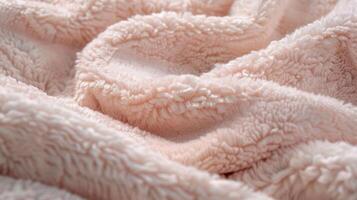 A detailed shot of a light pink sherpa material showing the smooth texture of the fabric photo