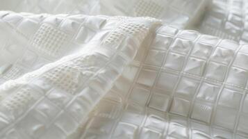 An array of small raised squares in a clean and orderly pattern on a white cotton percale creating a polished and refined texture photo