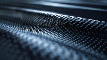 A closeup of carbon fiber reveals a finely textured surface with a delicate grainy pattern. The fibers seem to intertwine and create a soft smooth texture that begs to be touched photo