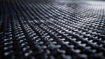 A closeup of a carbon fiber surface reveals a series of subtle overlapping layers giving off a sleek yet industrial feel. The matte finish exudes a sense of sophistication and elegance photo