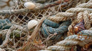 A closeup of a twisted and knotted fishing net with bits of sea debris and shells caught in its tangled fibers photo