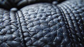 A macro shot of the shiny smooth surface of a black leather sofa featuring intricate stitching and subtle grain patterns photo