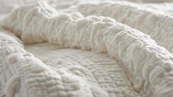 Soft fluffy clouds of white cotton create a textured effect on this quilted bedspread evoking a sense of dreamy comfort. The texture is both lightweight and luxurious making it perfec photo