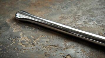 A simple straight handle with a smooth polished surface and rounded ends resembling a luxurious scepter fit for a king or queen photo