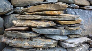 Textured river rock stacked in various sizes showing layers of sediment and mineral deposits photo
