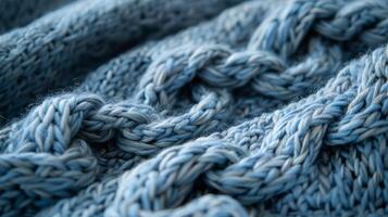 A detailed shot of delicate woven braids in a soft heathered blue woolen throw adding depth and charm to the fabric photo