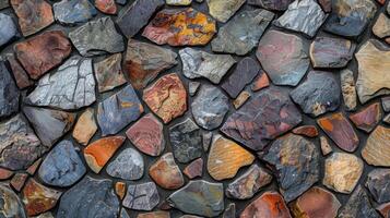 A patchwork of differently sized and shaped stones creating an intricate mosaiclike texture on the surface of a stone wall photo
