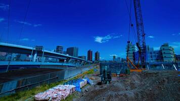 A timelapse of moving cranes at the under construction in Tokyo wide shot zoom video