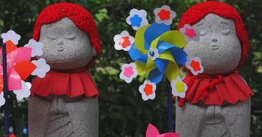 Statue guardian wearing red hat in Tokyo daytime closeup video