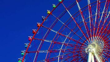 A timelapse of ferris wheel at the amusement park in Odaiba Tokyo daytime long shot zoom video