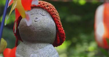 Statue guardian wearing red hat daytime handheld video