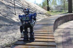 Robot on wooden surface outdoor. Kid's toy. Big model of robot. photo