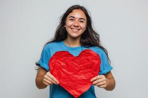 sonriente mujer participación grande rojo corazón en contra blanco antecedentes foto