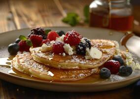 Stack of Pancakes With Fresh Berries and Syrup on Wooden Table photo