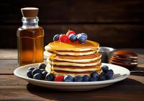 Stack of Pancakes With Fresh Berries and Syrup on Wooden Table photo