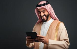 sonriente hombre en tradicional ropa usos tableta foto