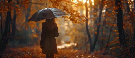 Woman Walking Through Autumn Forest With Umbrella photo