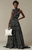 Woman Wearing Black And White Polka Dot Dress And Holding A White Bag photo