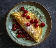 Sweet Crepe With Cherries and Green Sauce on a Plate photo