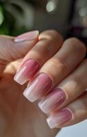 Close Up of a Hand With Pink Ombre Nail Polish photo