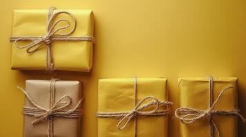 Four Gift Boxes Tied With Twine on a Yellow Background photo