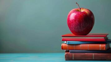 Red Apple on Stack of Books With Green Background photo