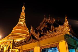 The golden pagodas and mondops are illuminated in the light of the night photo