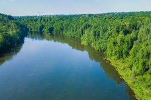 Breathtaking Landscape A Beautiful River Flows Through Charming Air and Lush Trees, Creating a Serene and Picturesque Natural Haven for All to Enjoy photo