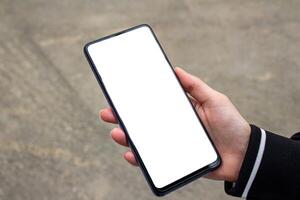 Hand holding a smartphone with blank white screen. Mockup phone. photo